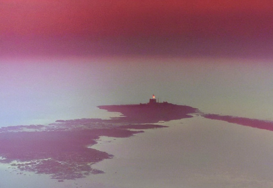 Lighthouse on Island Surrounded by Calm Waters
