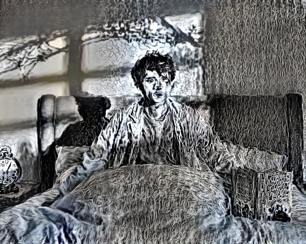 Young man in bed with contemplative expression and light.