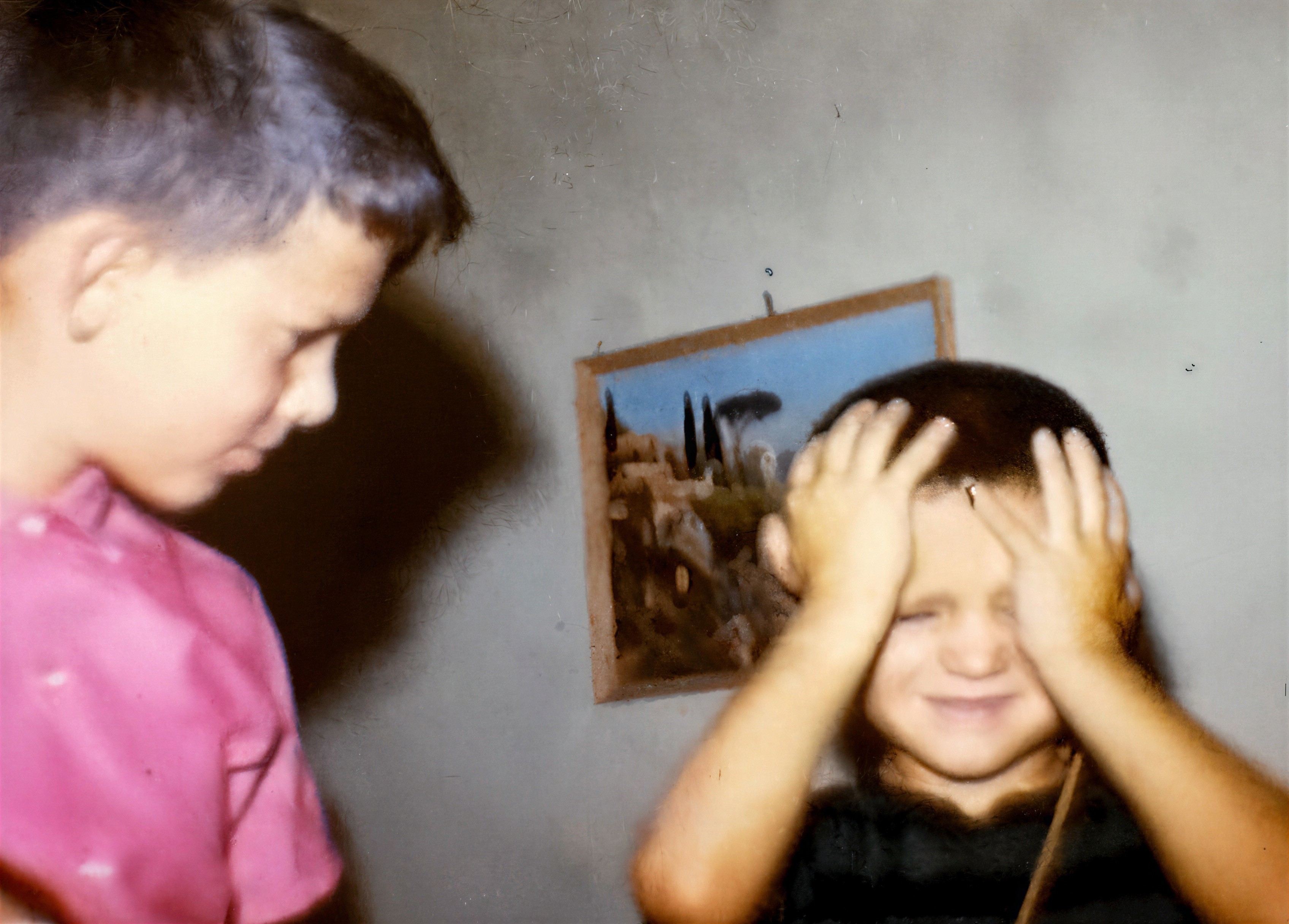 Close-Up of Two Boys Indoors with Framed Painting